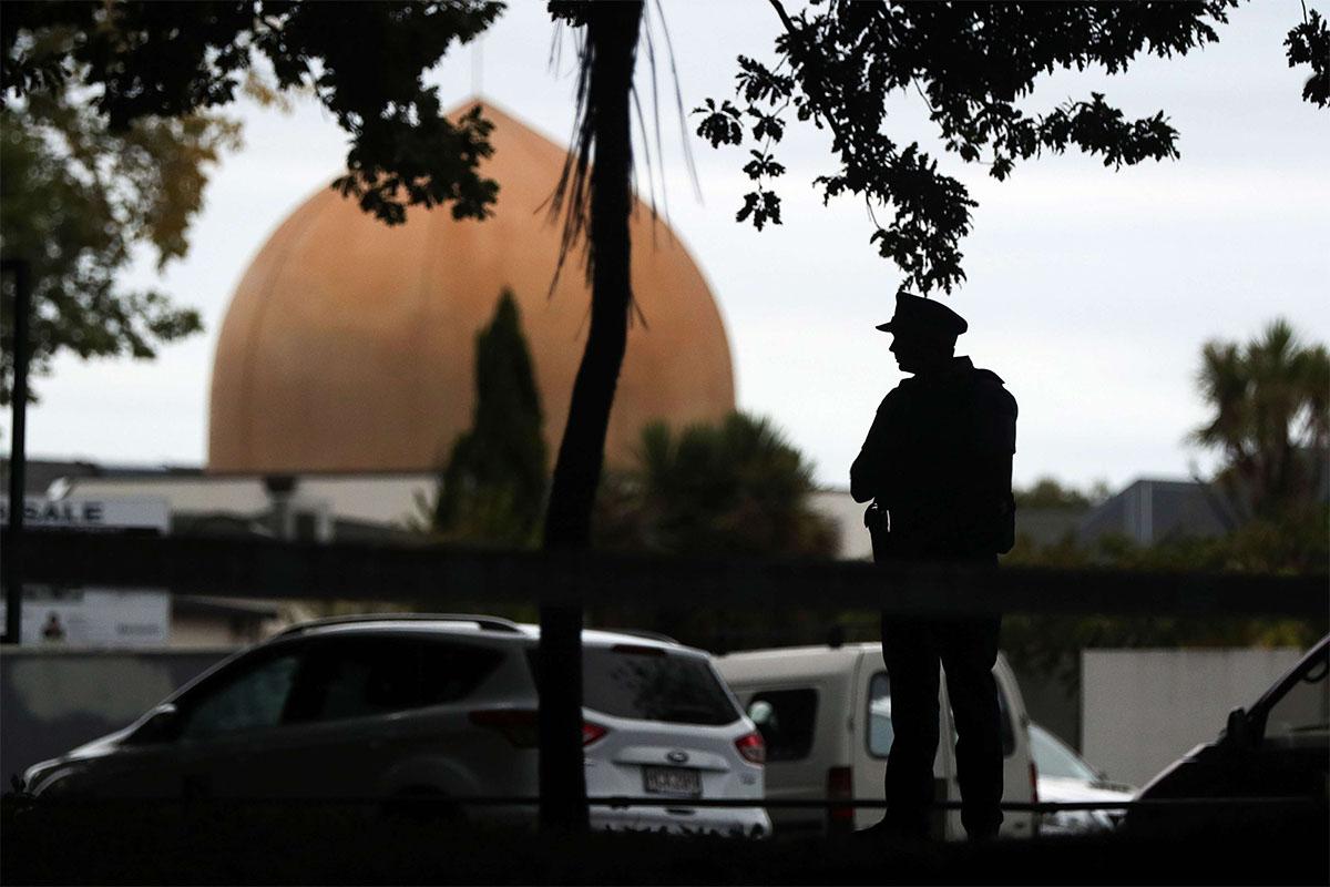 An armed policeman stands guard in front of the Masjid Al Noor Mosque in Christchurch