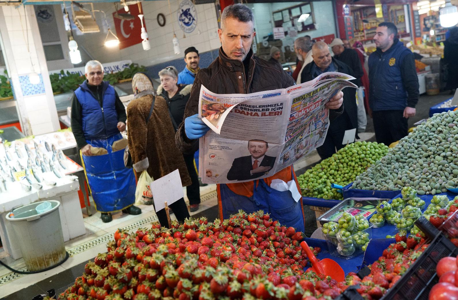 A stallholder reads a newspaper as he waits for customers at a bazaar in Ankara, Turkey, March 26, 2019.