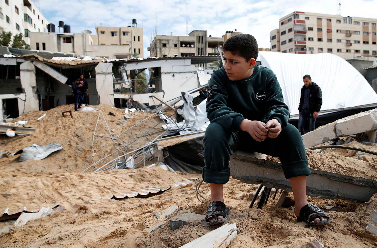 طفل فلسطيني عند مبنى مدمر في القصف الاسرائيلي