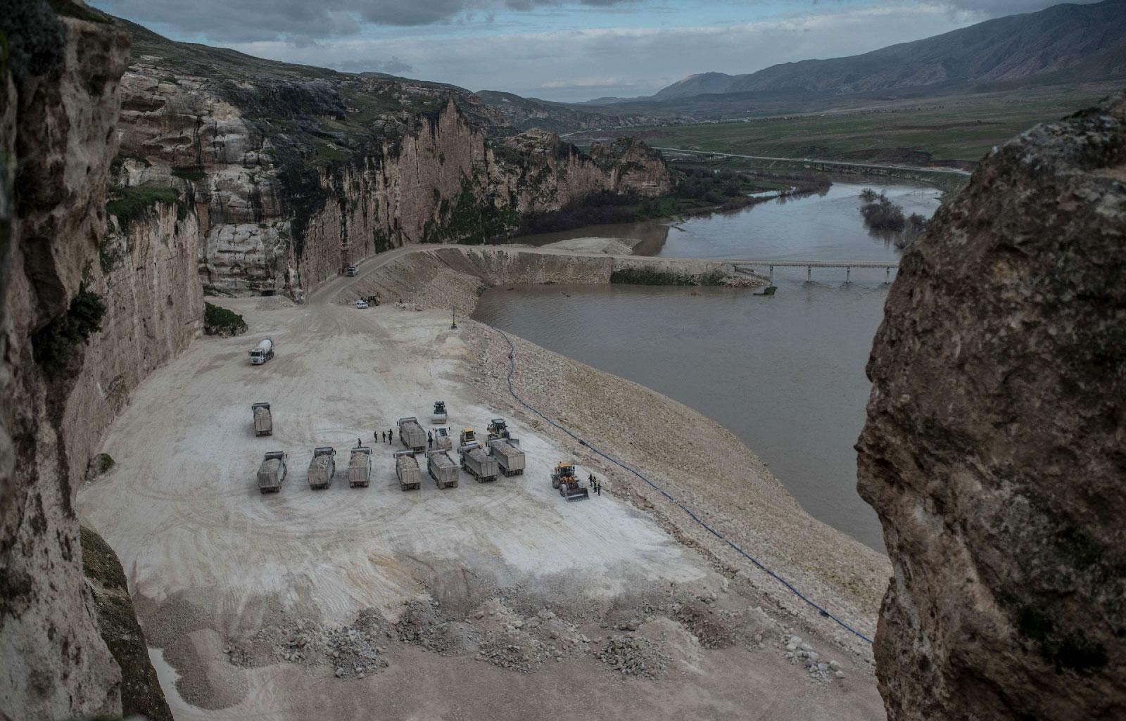Trucks are seen on the banks of the Tigris river near Hasankeyf, in Turkey's Kurdish-majority southeast, on December 13, 2018, during the construction of the Ilisu dam.