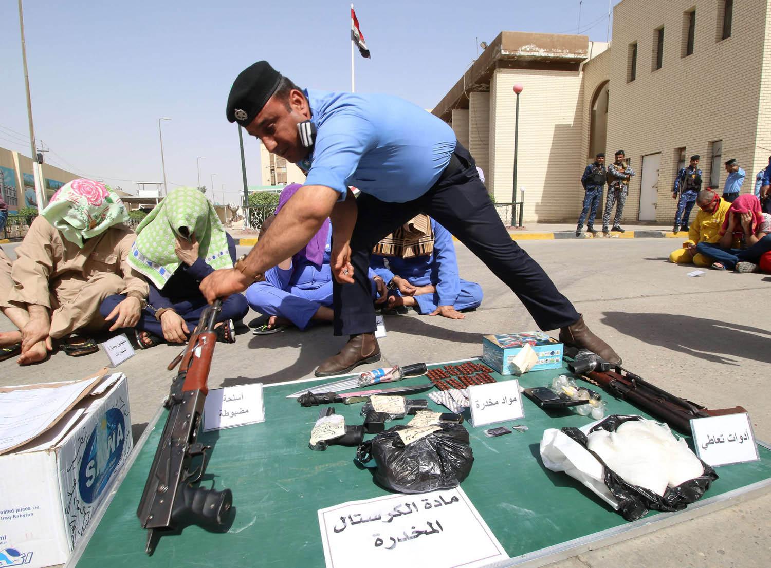 شرطي عراقي يعرض أحرازا قضائية لمخدرات وسلاح مع عصابة تهريب للمخدرات