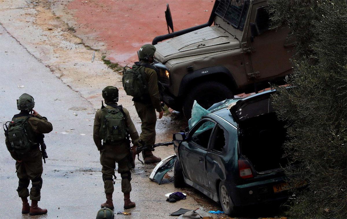 Israeli forces stand at the scene of the incident near Ramallah