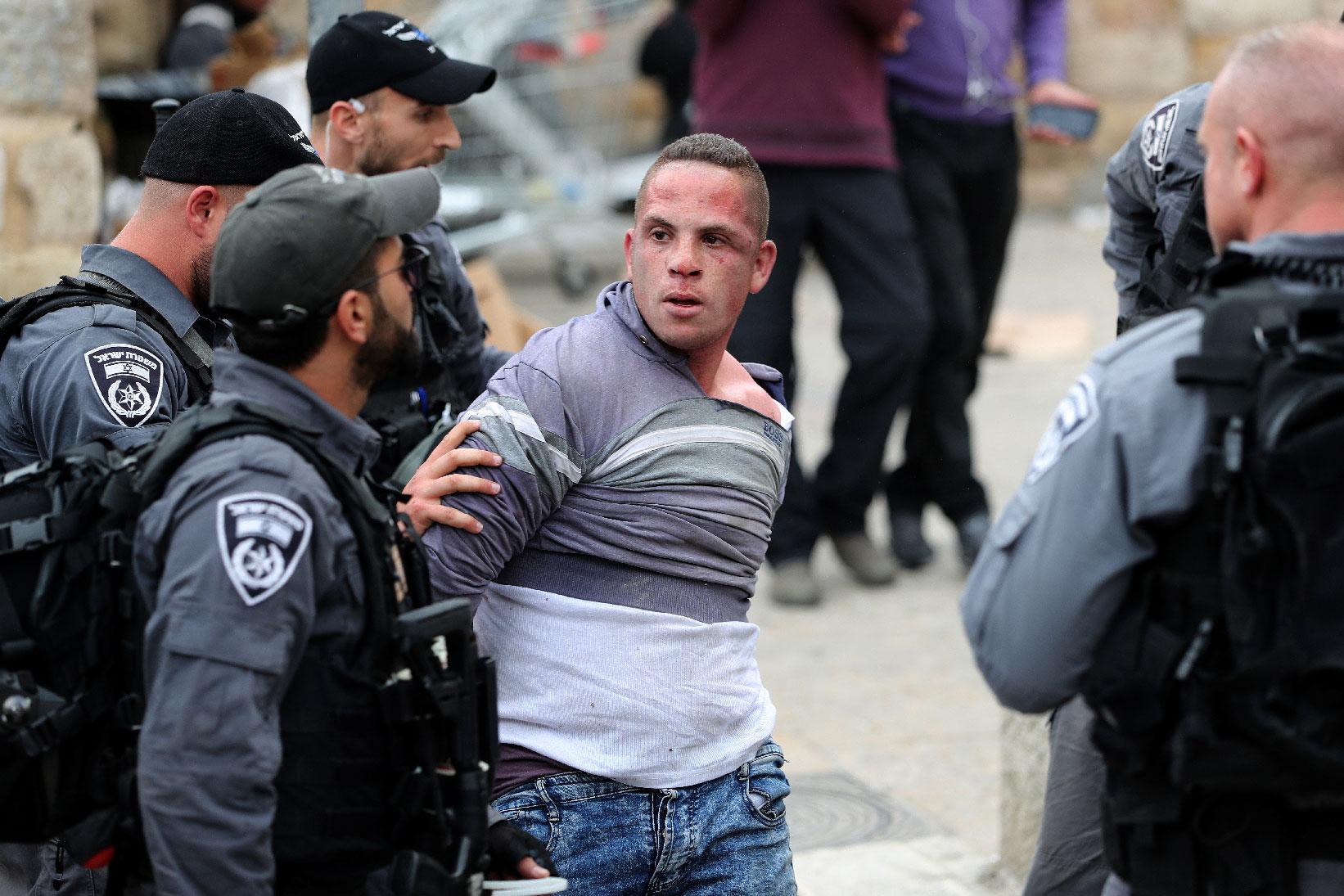 Israeli policemen detain a Palestinian protester during scuffles outside the compound housing al-Aqsa Mosque in occupied East Jerusalem's Old City March 12, 2019.