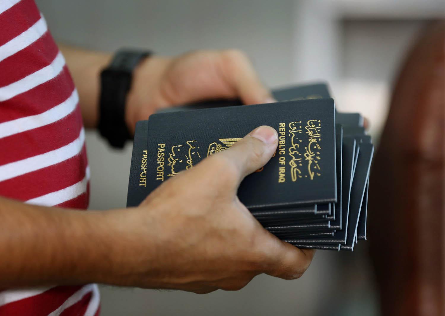 عراقي يحمل جوازات سفر في مكتب السفر في بغداد
