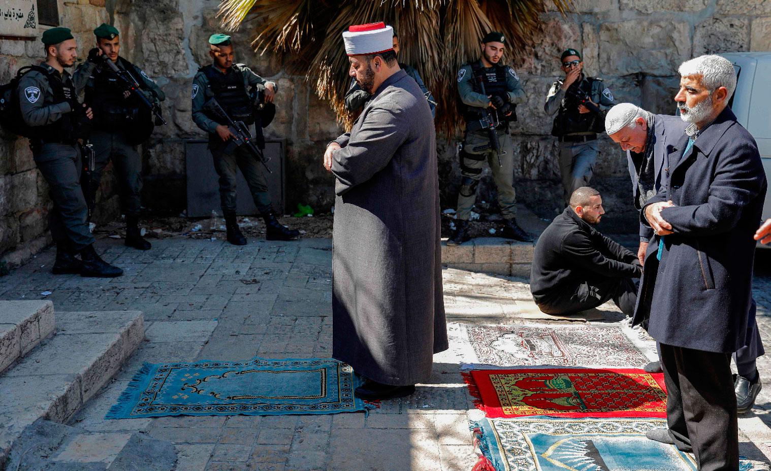 Palestinians, including clerics, pray outside the Lion's Gate entrance to the Aqsa mosque compound on March 8, 2019.