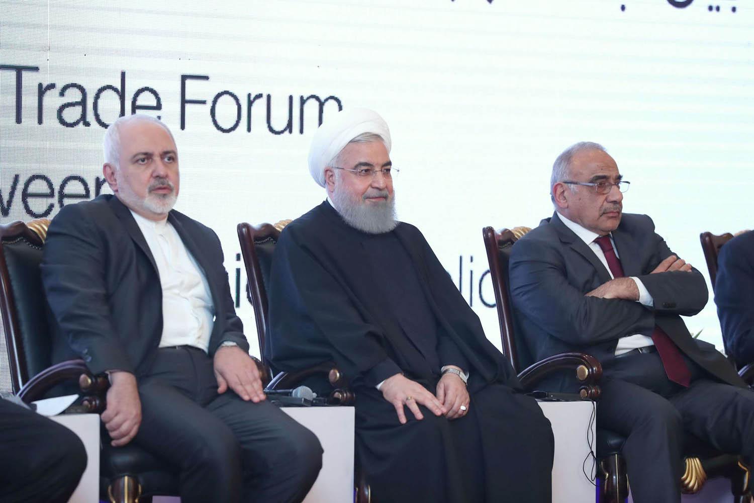 الرئيس الإيراني حسن روحاني يتوسط رئيس الوزراء العراقي عادل عبدالمهدي ووزير الخارجية الإيراني محمد جواد ظريف في ملتقى اقتصادي في بغداد