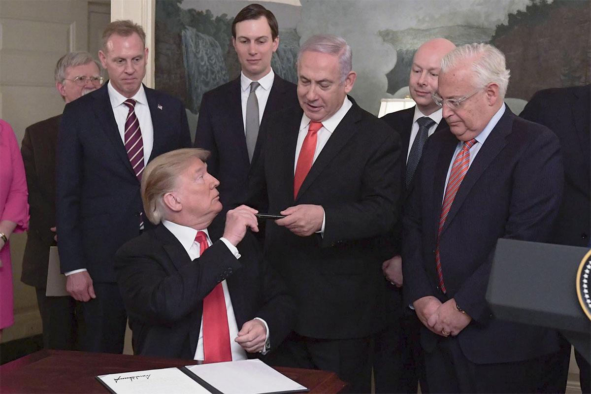 Trump signing a proclamation recognising Israeli sovereignty over occupied Golan Heights