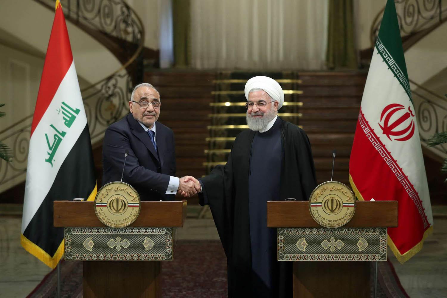 الرئيس الإيراني حسن روحاني يصافح رئيس الوزراء العراقي عادل عبدالمهدي خلال زيارته لطهران