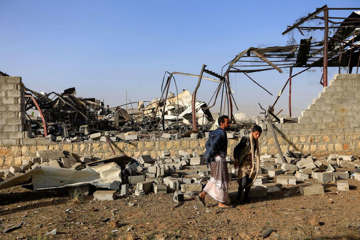  Civilians inspect the damage after a reported airstrike by Saudi-led coalition