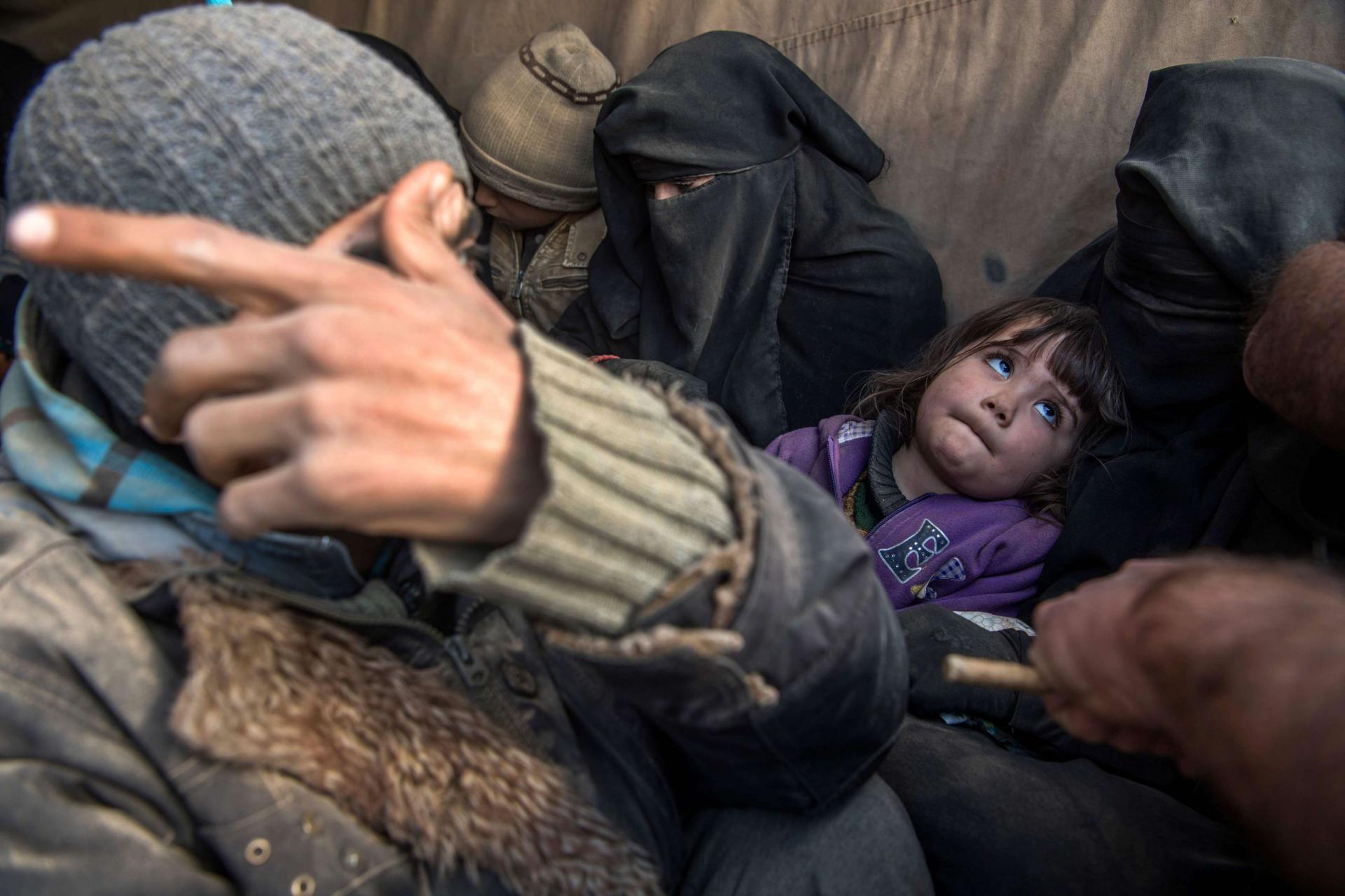 Women and children displaced from Deir Ezzor sit in the back of a truck after they fled the Islamic State (IS) holdout near Baghuz, eastern Syria, on February 11, 2019.