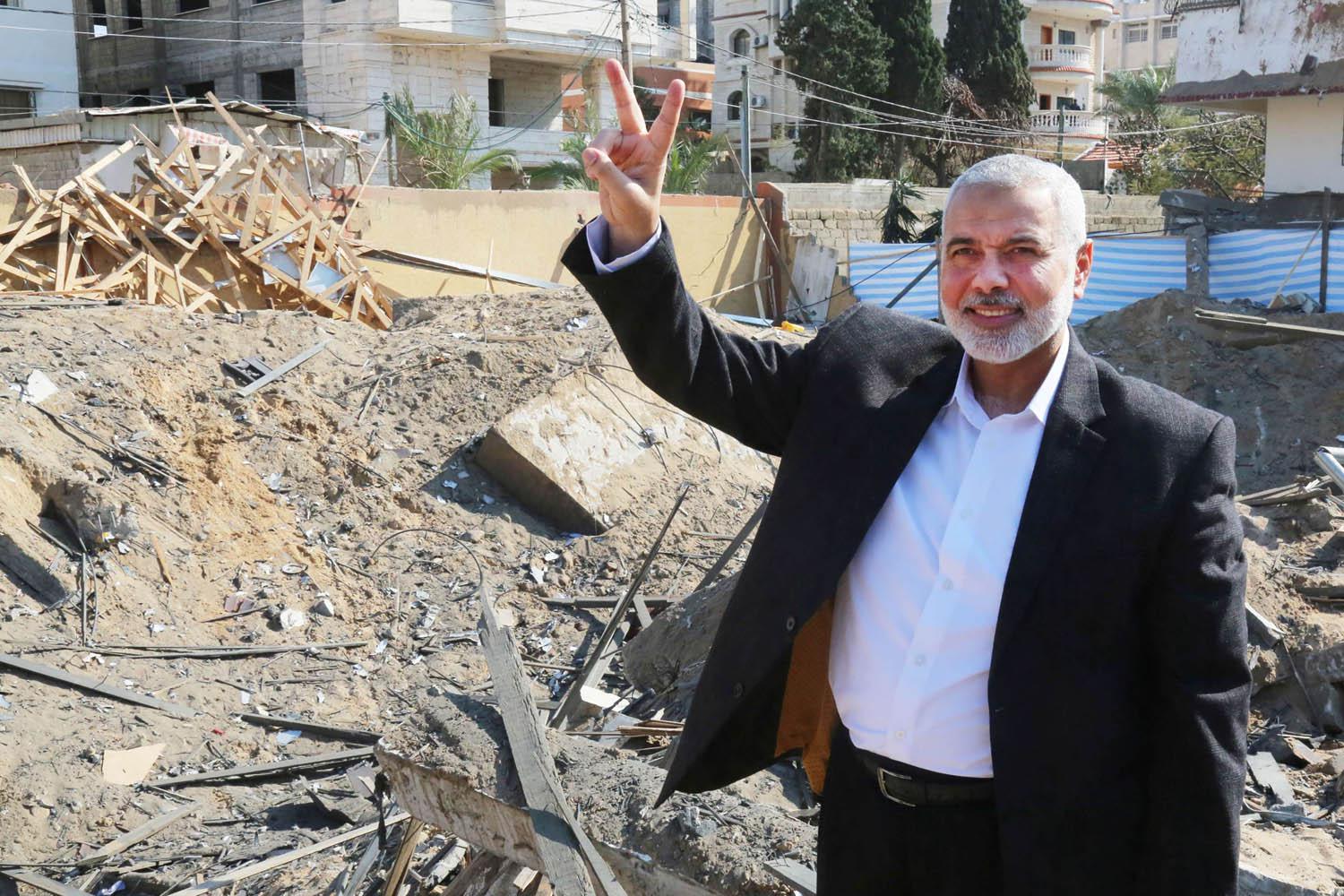زعيم حركة حماس إسماعيل هنية يرفع إشارة النصر بالقرب من مبنى دمره الإسرائيليون