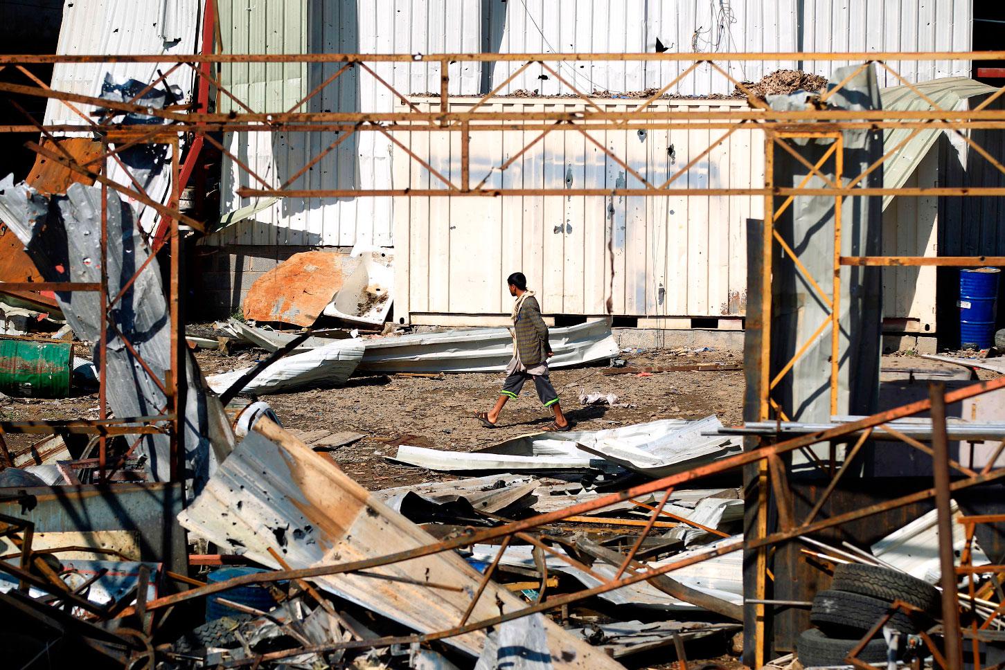 A man walks amidst the debris following a reported air strike on a plastic factory in Sanaa's Jeraf district on April 10, 2019.
