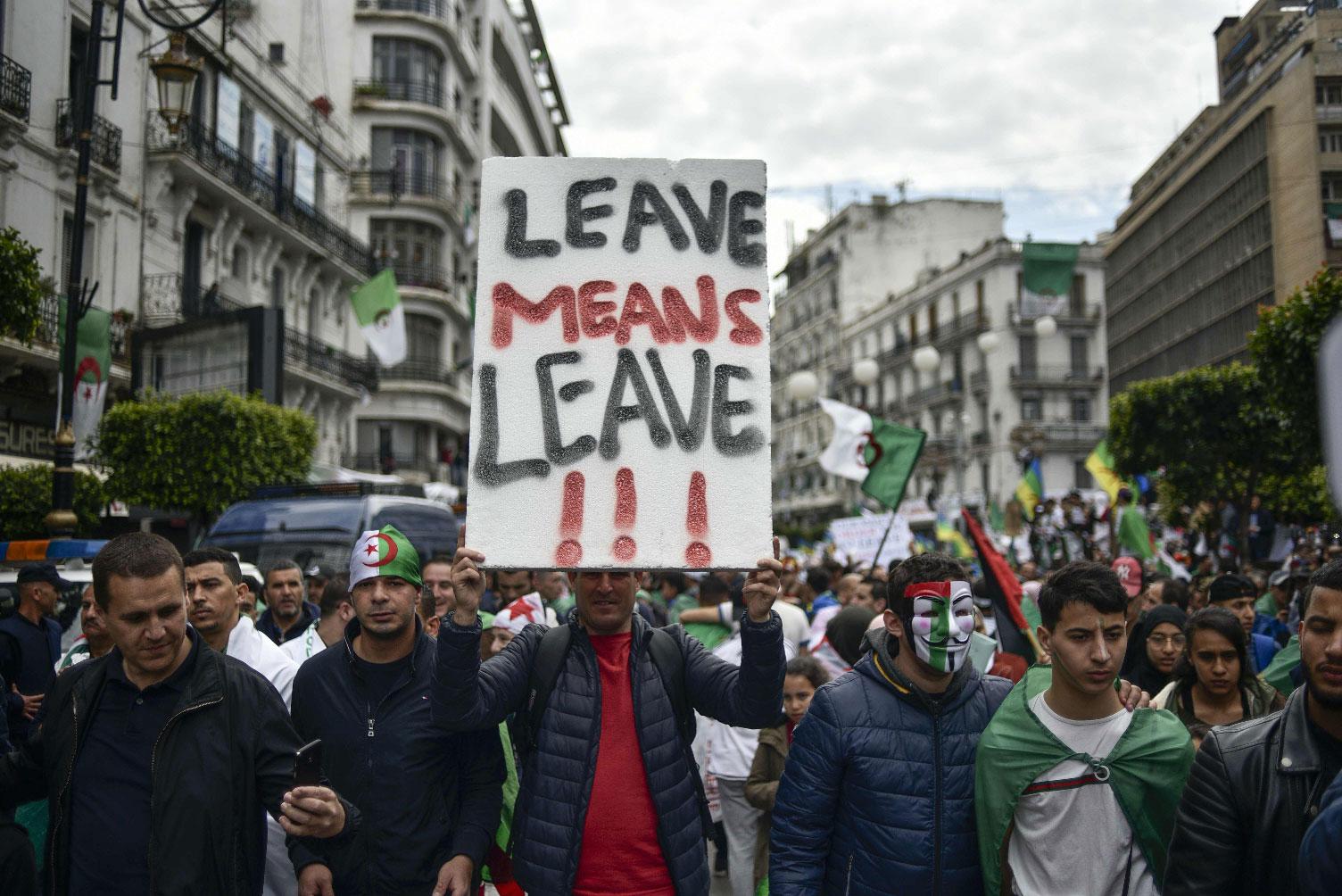 Algerians raise a placard as they take part in an anti-government demonstration, on April 5, 2019 in the capital Algiers. 