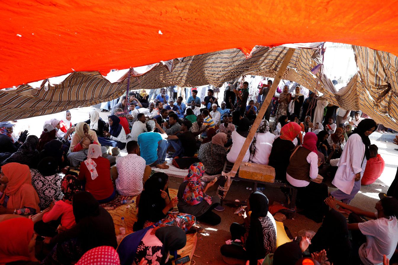Sudanese protesters gather under a tent outside the defense ministry compound in Khartoum