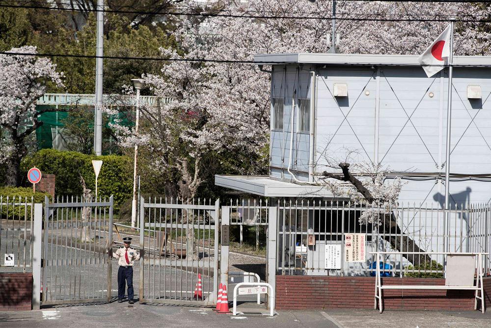 أحد الحراس يغلق بوابة سجن طوكيو حيث يتم احتجاز رئيس نيسان السابق كارلوس غصن