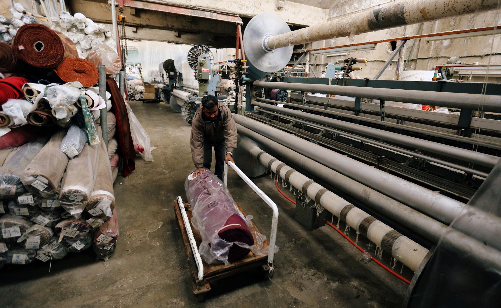 A man pushes a cart at the Mzannar family's fabric factory which has stopped production, in Baabda, Lebanon February 12, 2019.