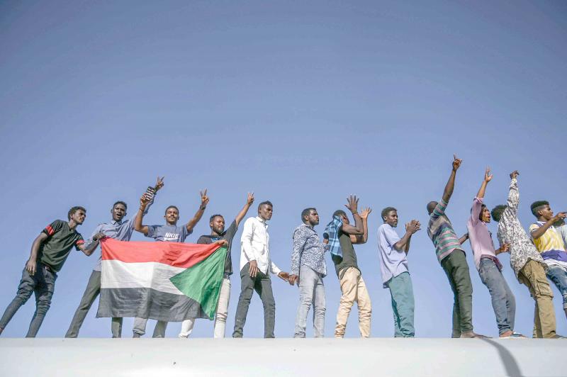 Sudanese protesters from the city of Atbara flash the victory sign in Khartoum, April 23