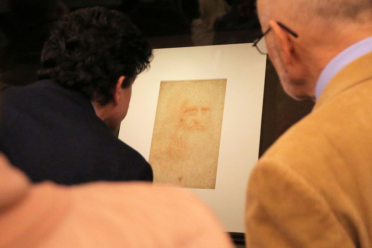 زوار ينظرون إلى بورتريه للفنان ليوناردو دافينشي في تورينو بايطاليا