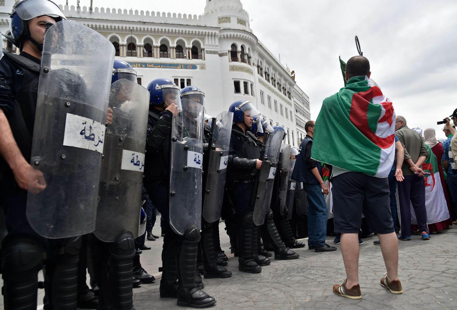 متظاهر جزائري أمام قوات الشرطة في الجزائر