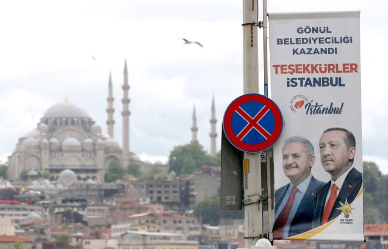 An election banner with pictures of Turkish President Recep Tayyip Erdogan and ruling party mayoral candidate Binali Yildirim is seen over the Galata bridge in Istanbul