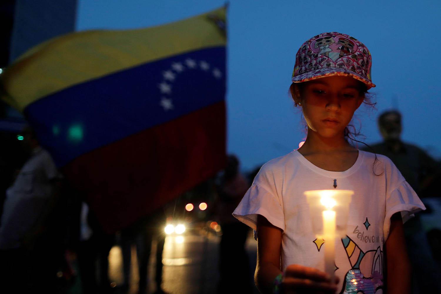 طفلة تحمل شمعة في تظاهرة في كاركاس