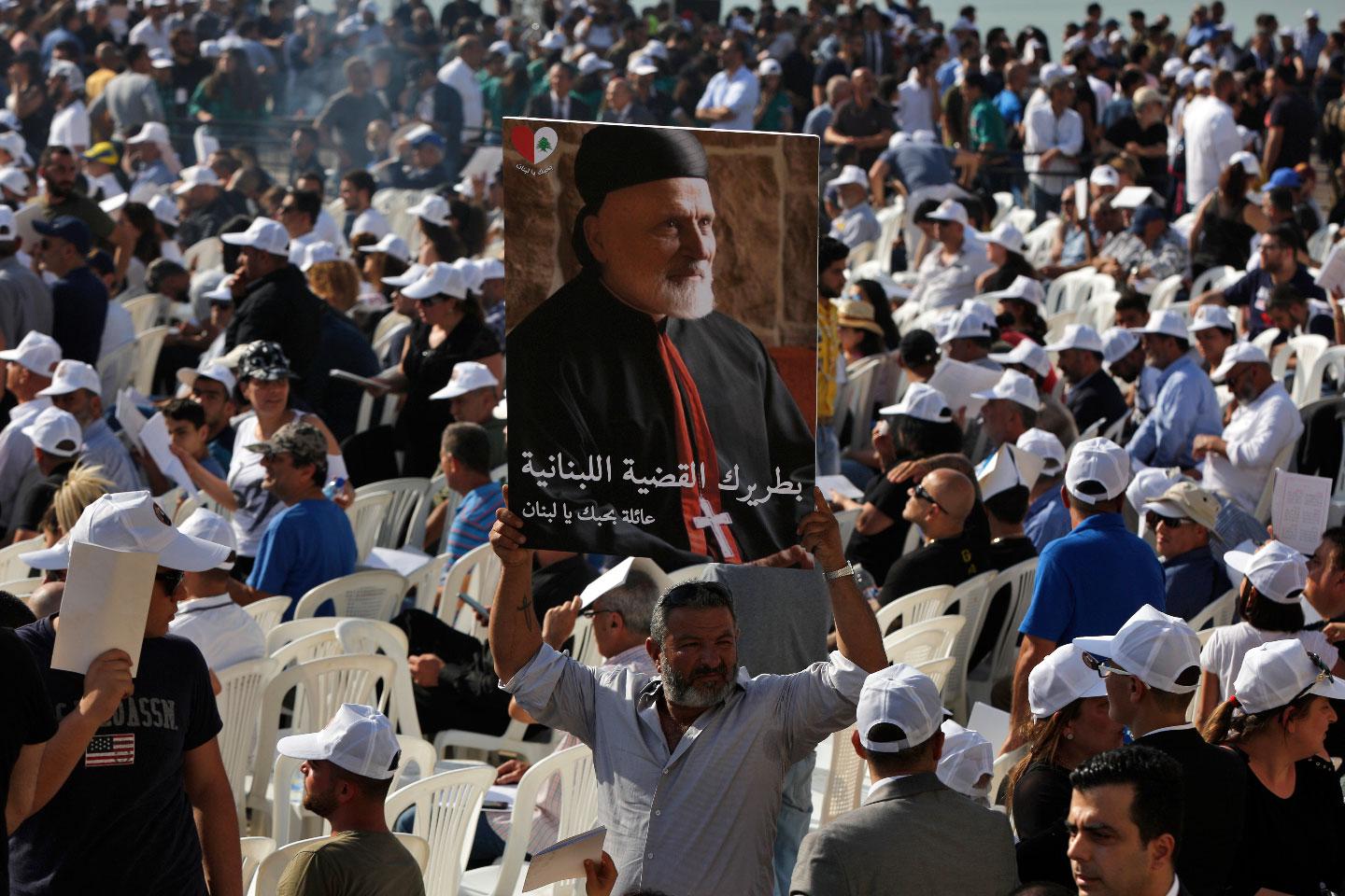 A mourner holds up a picture of former Maronite Patriarch Cardinal Mar Nasrallah Boutros Sfeir