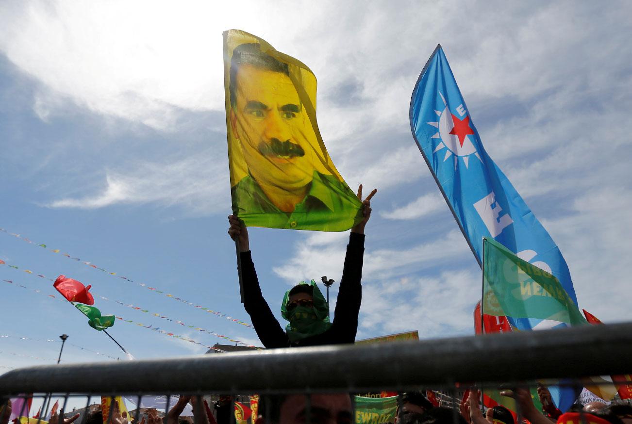 A man holds a flag with a picture of imprisoned Kurdish rebel leader Abdullah Ocalan