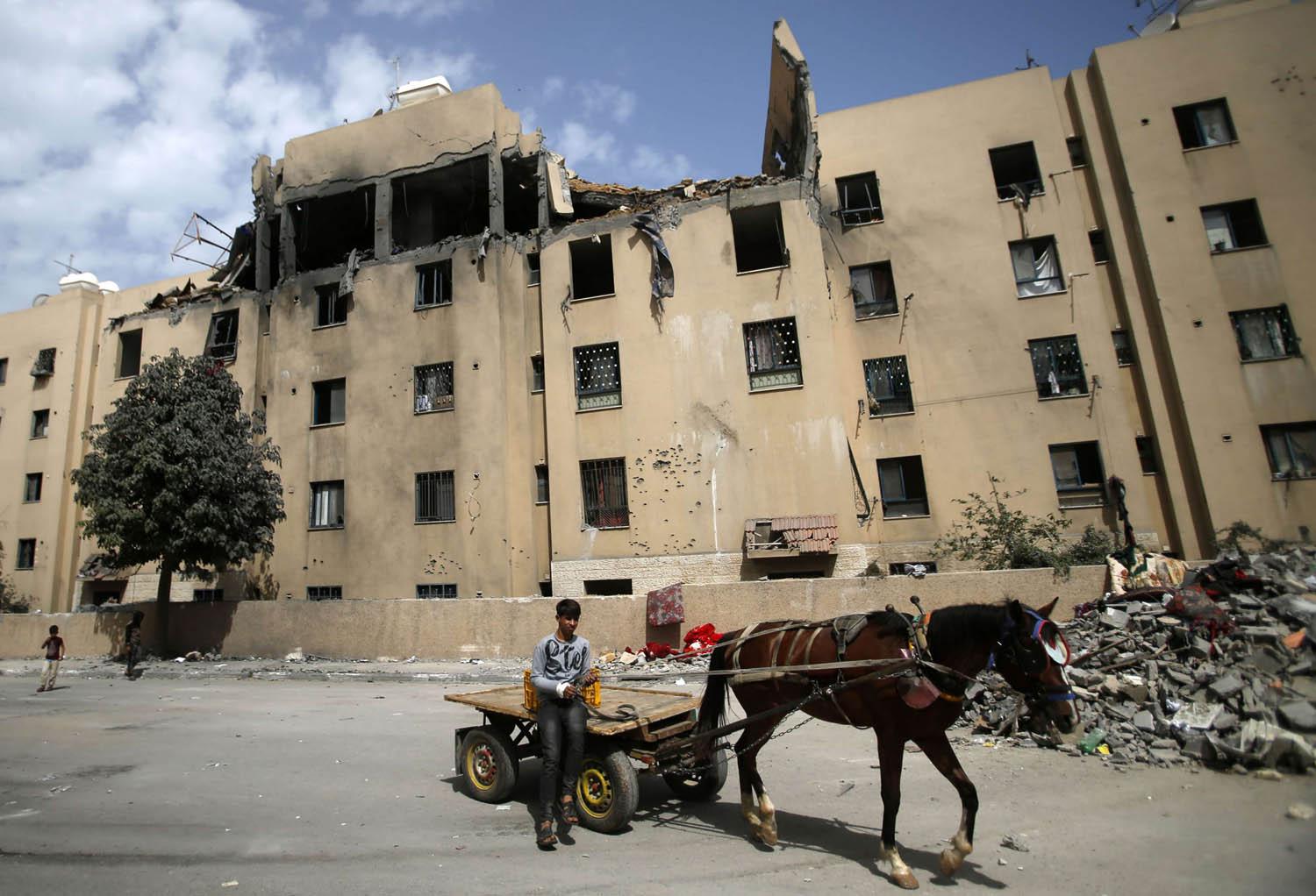 عربة تمر أمام مبنى مدمر في غزة