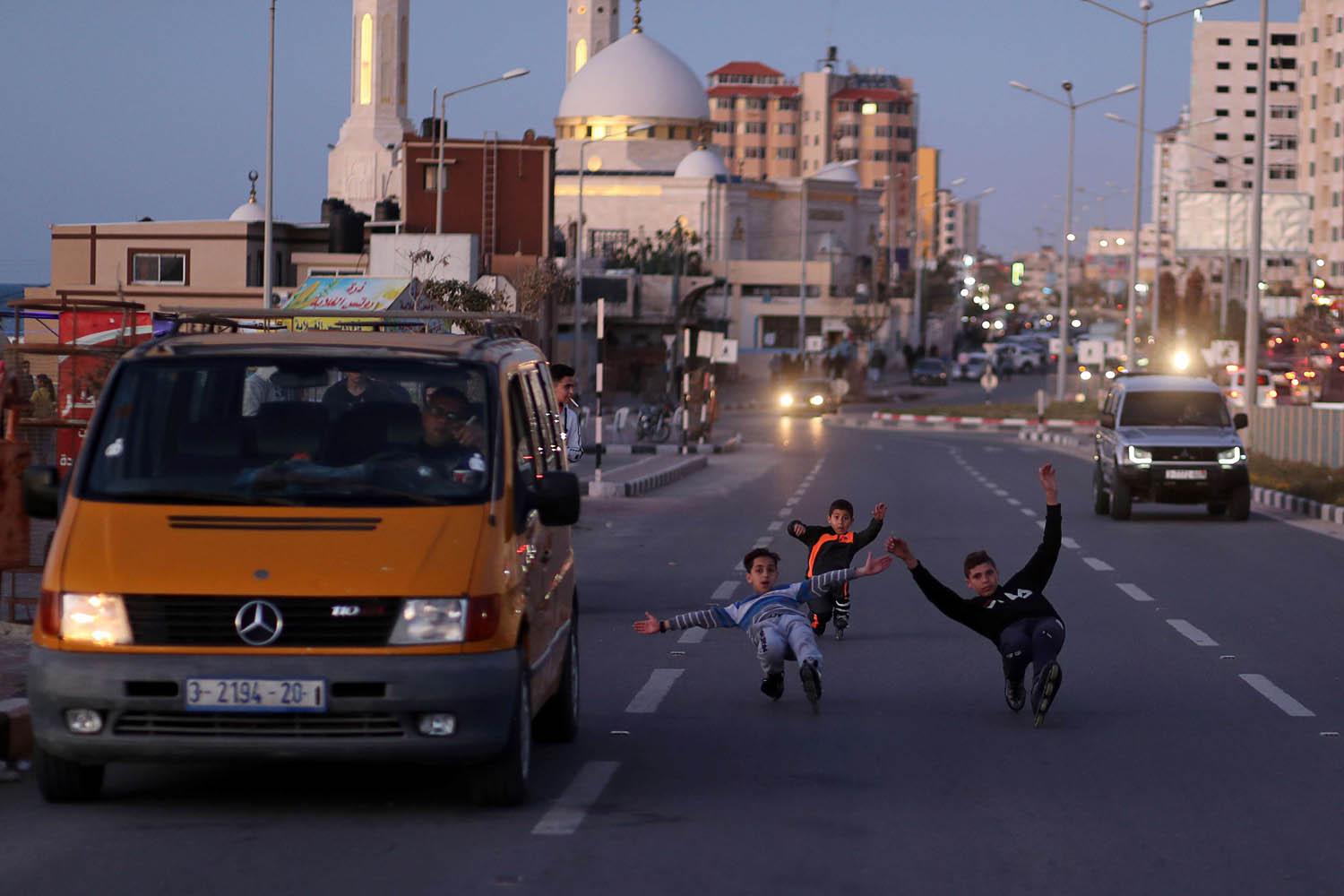 أطفال فلسطينيون يتزحلقون في شوارع غزة