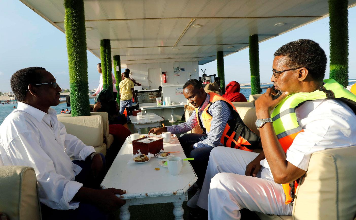 Passengers sit on the lower deck onboard of the La Lanterna Bar restaurant boat