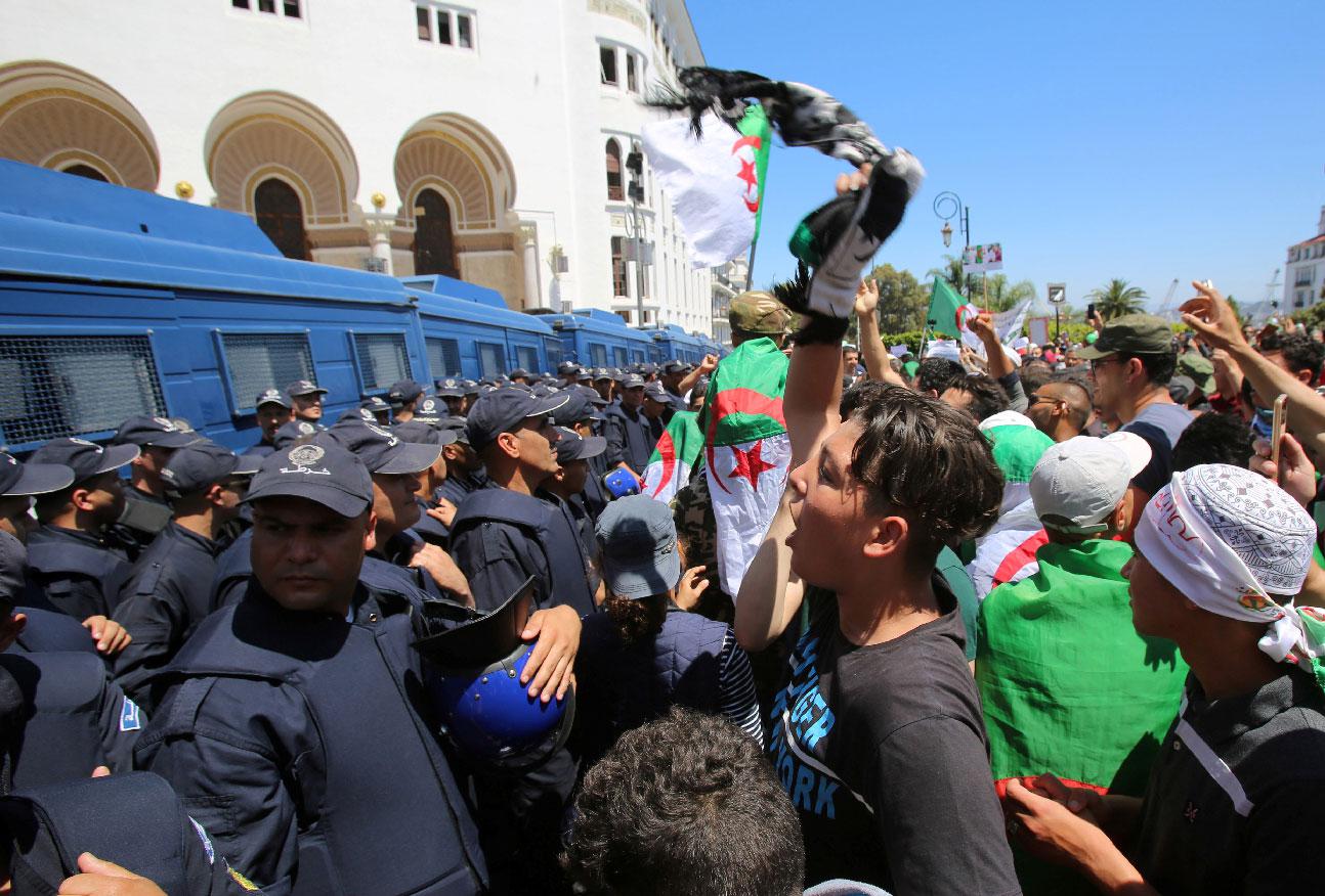 A demonstrator chants slogans in front of police during an anti-government protest in Algiers