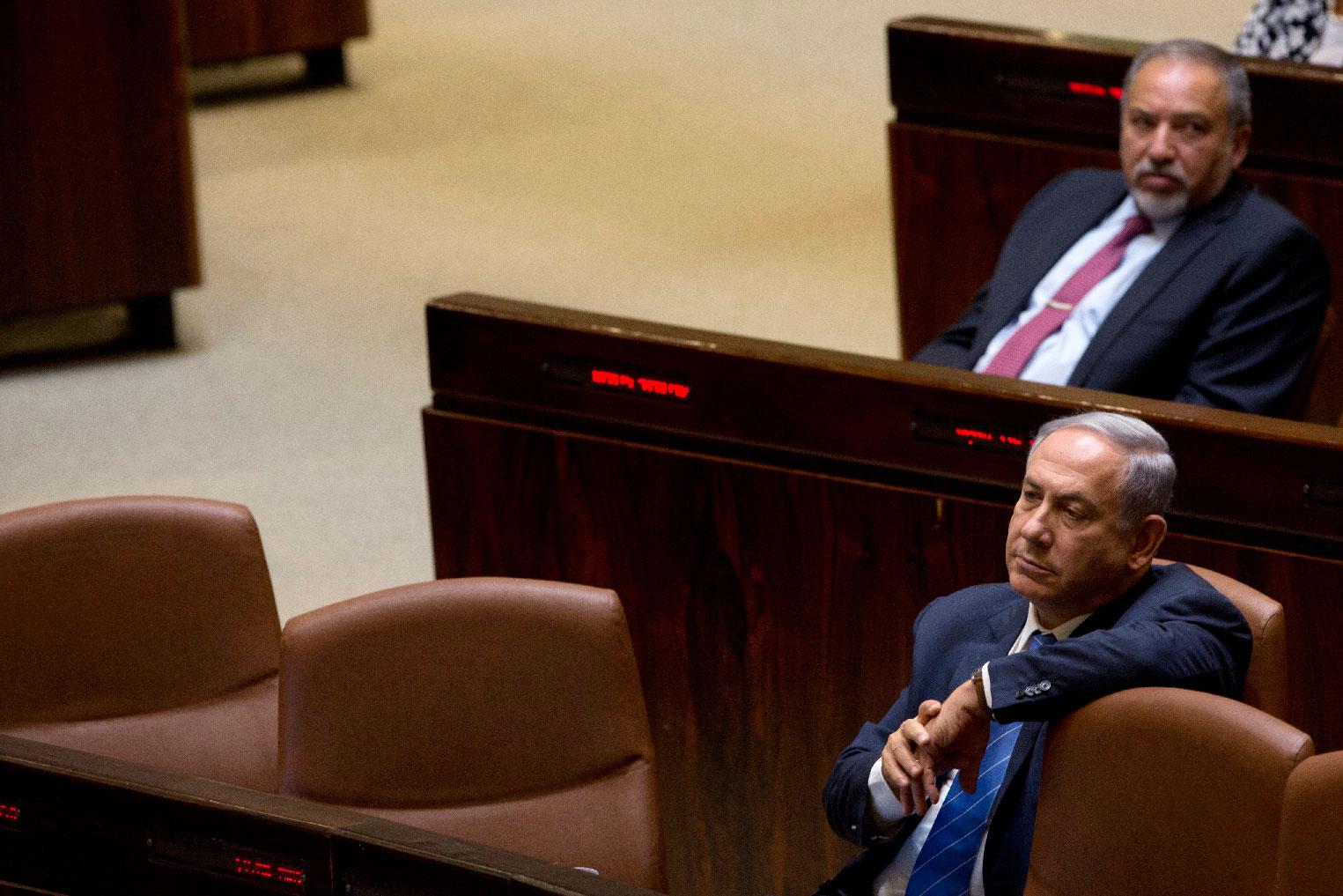 Israeli Prime Minister Benjamin Netanyahu and former Israeli Defense Minister Avigdor Lieberman sit in the Knesset