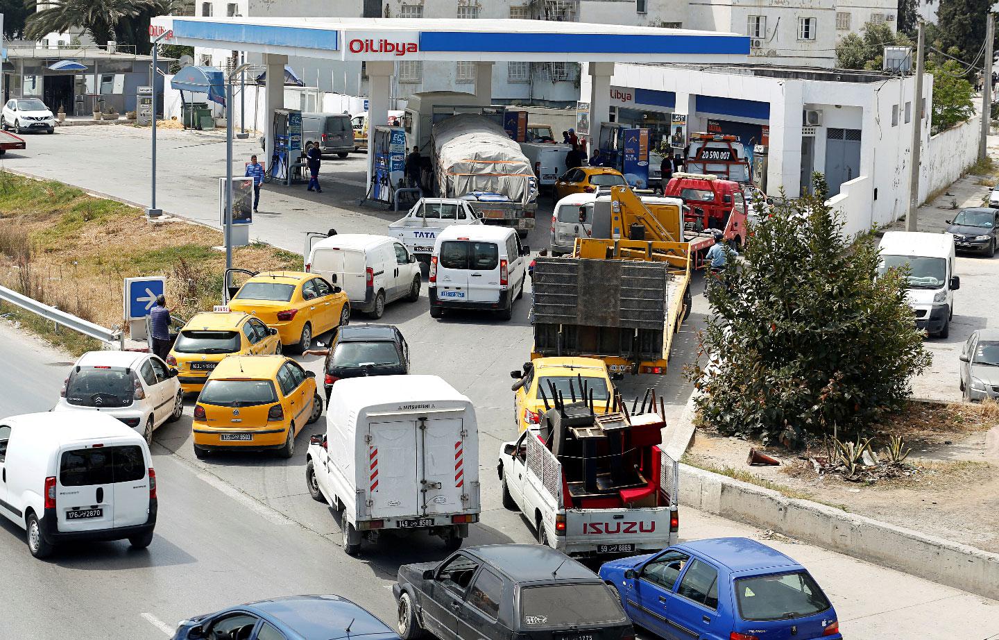 Automobiles line up for gasoline at a gas station in Tunis