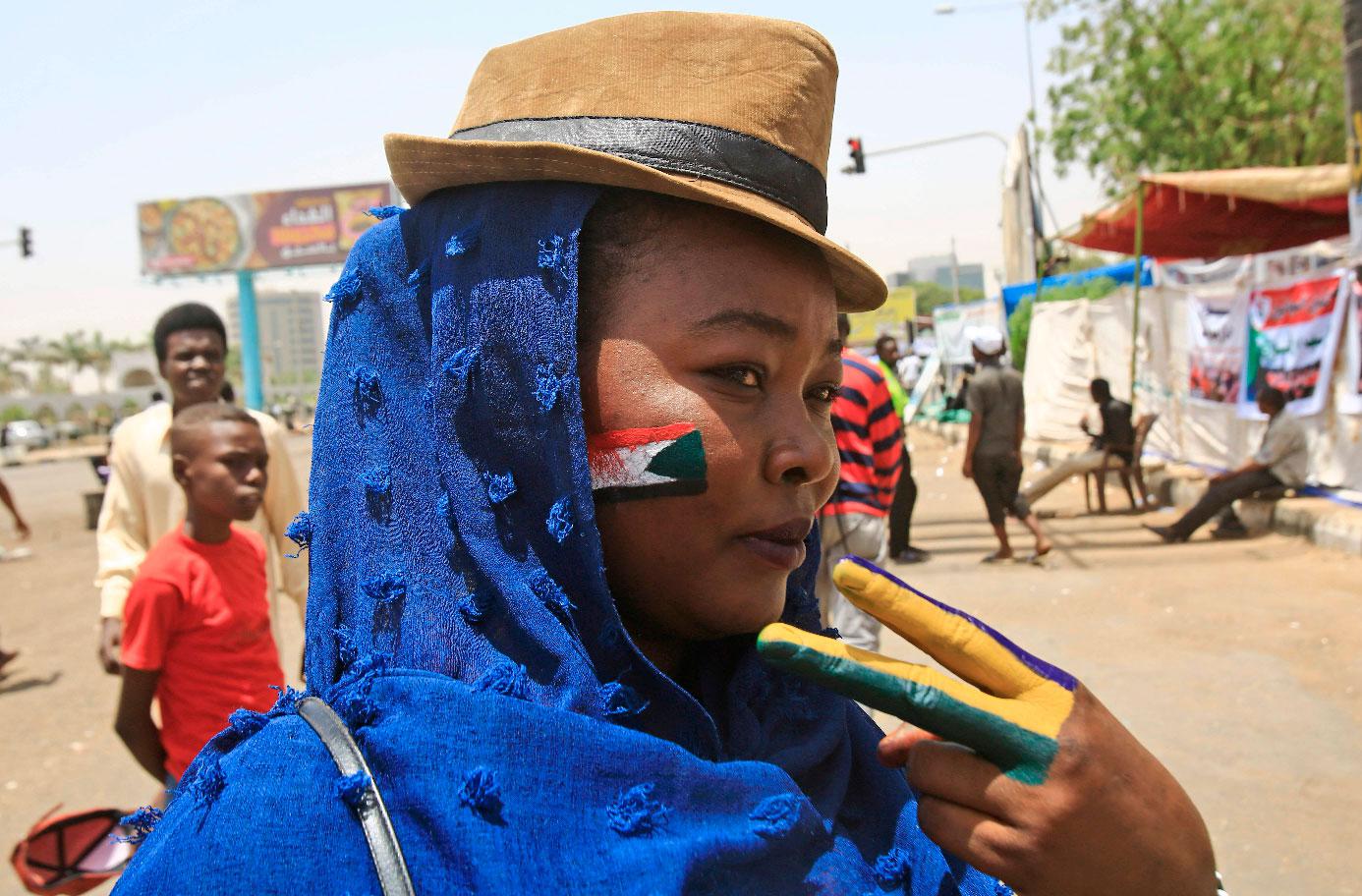 A Sudanese protester with the national flag of Sudan painted on her face