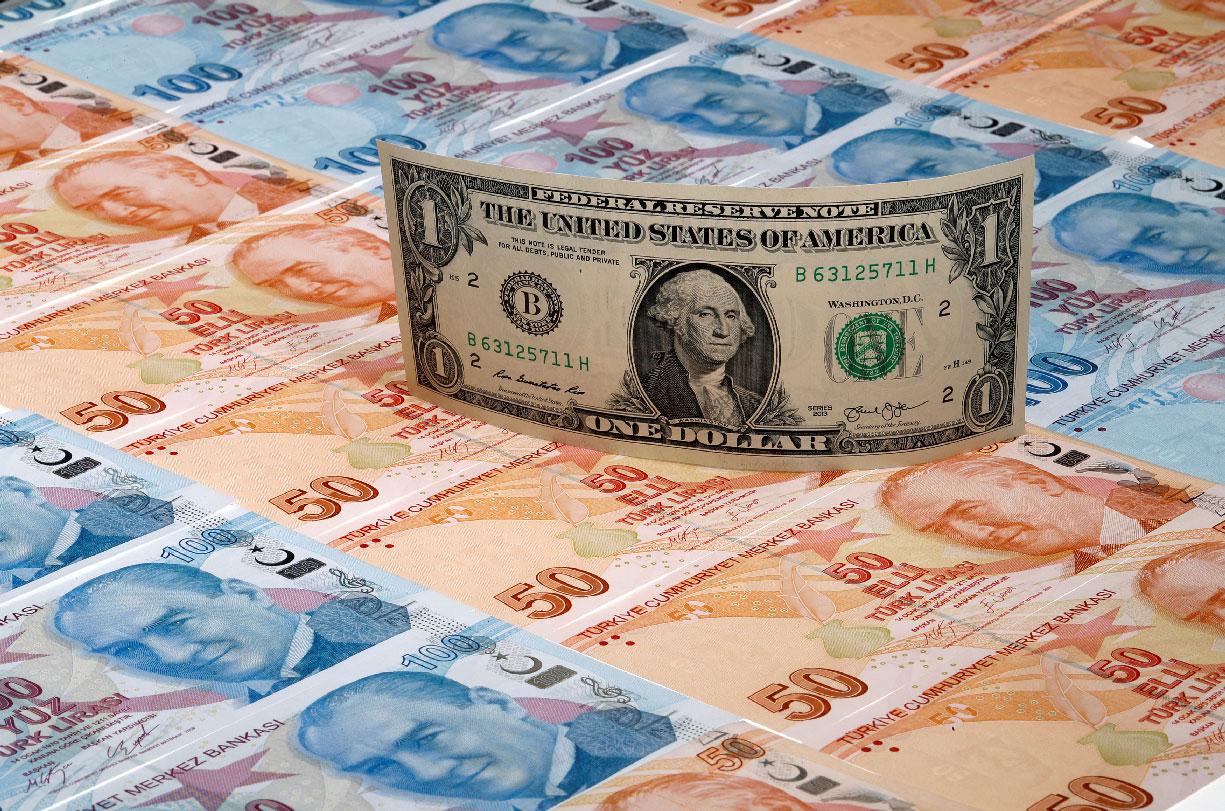 A US dollar banknote is seen on top of 50 and 100 Turkish lira banknotes in this picture illustration in Istanbul