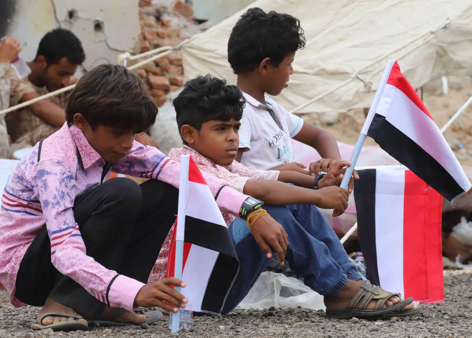 أطفال يمنيون يرفعون اعلاما في احتفال لبرنامج المساعدات السعودي لليمن في حجة