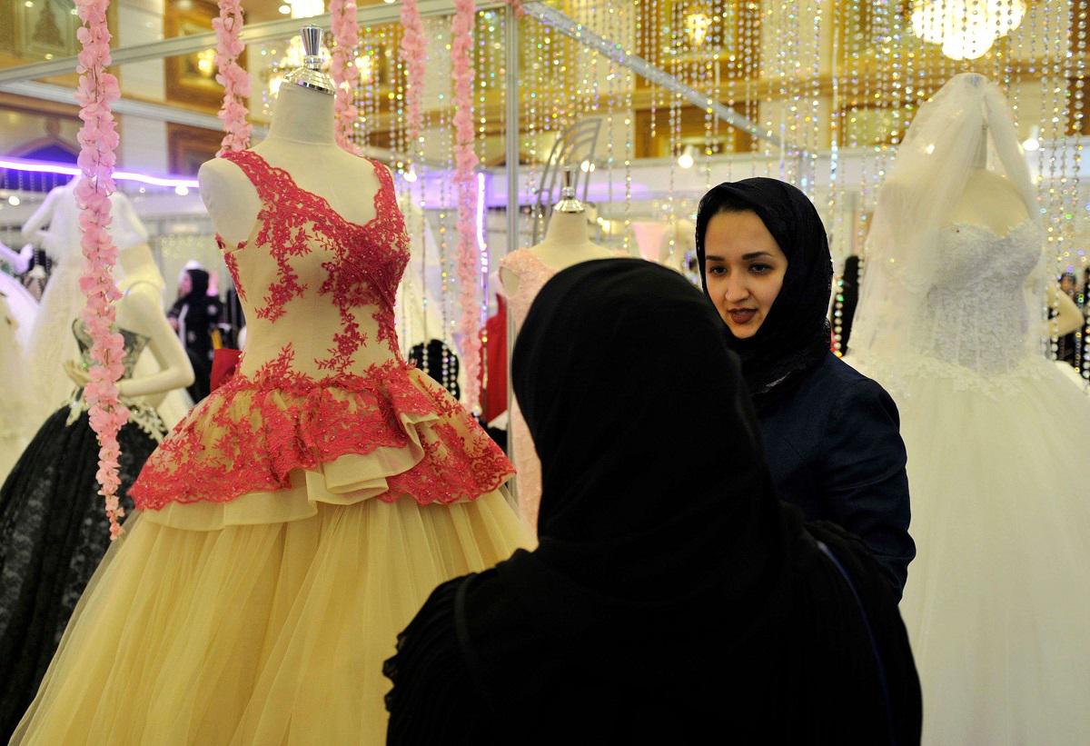 امرأة سعودية تعاين مع صديقتها فساتين الزفاف في جدة