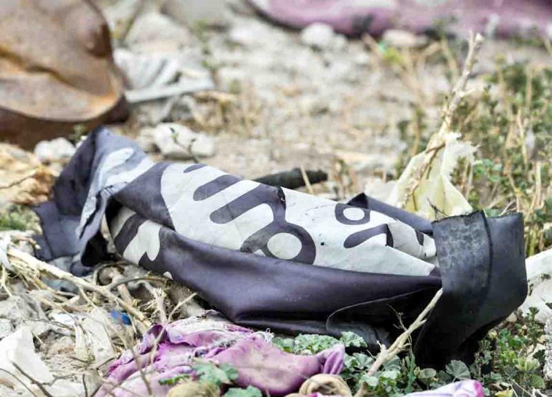 A discarded ISIS flag lies on the ground in the village of Baghouz in Syria’s eastern province of Deir ez-Zor