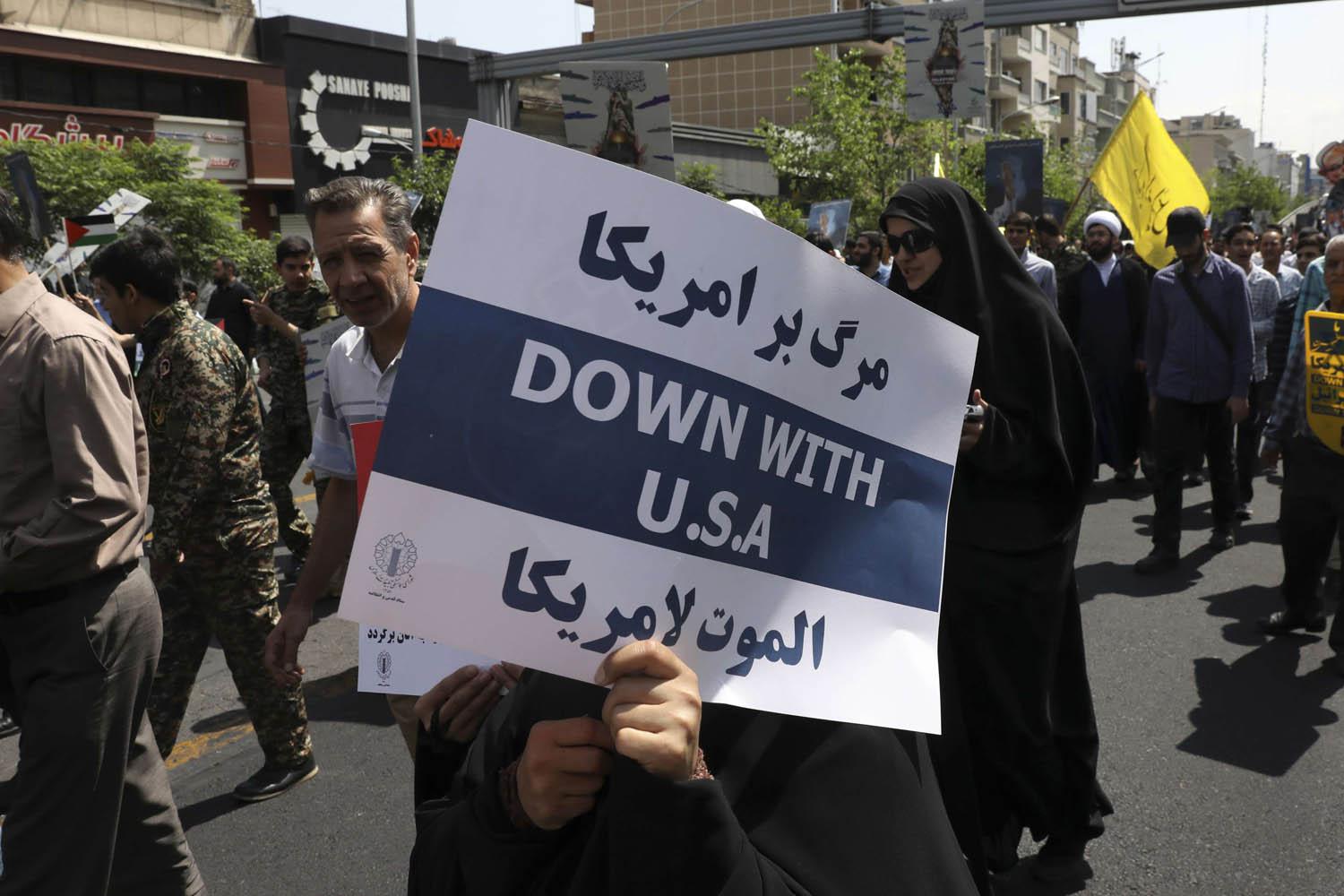 إيرانية ترفع شعارا في مسيرة ضد الولايات المتحدة في شوارع طهران