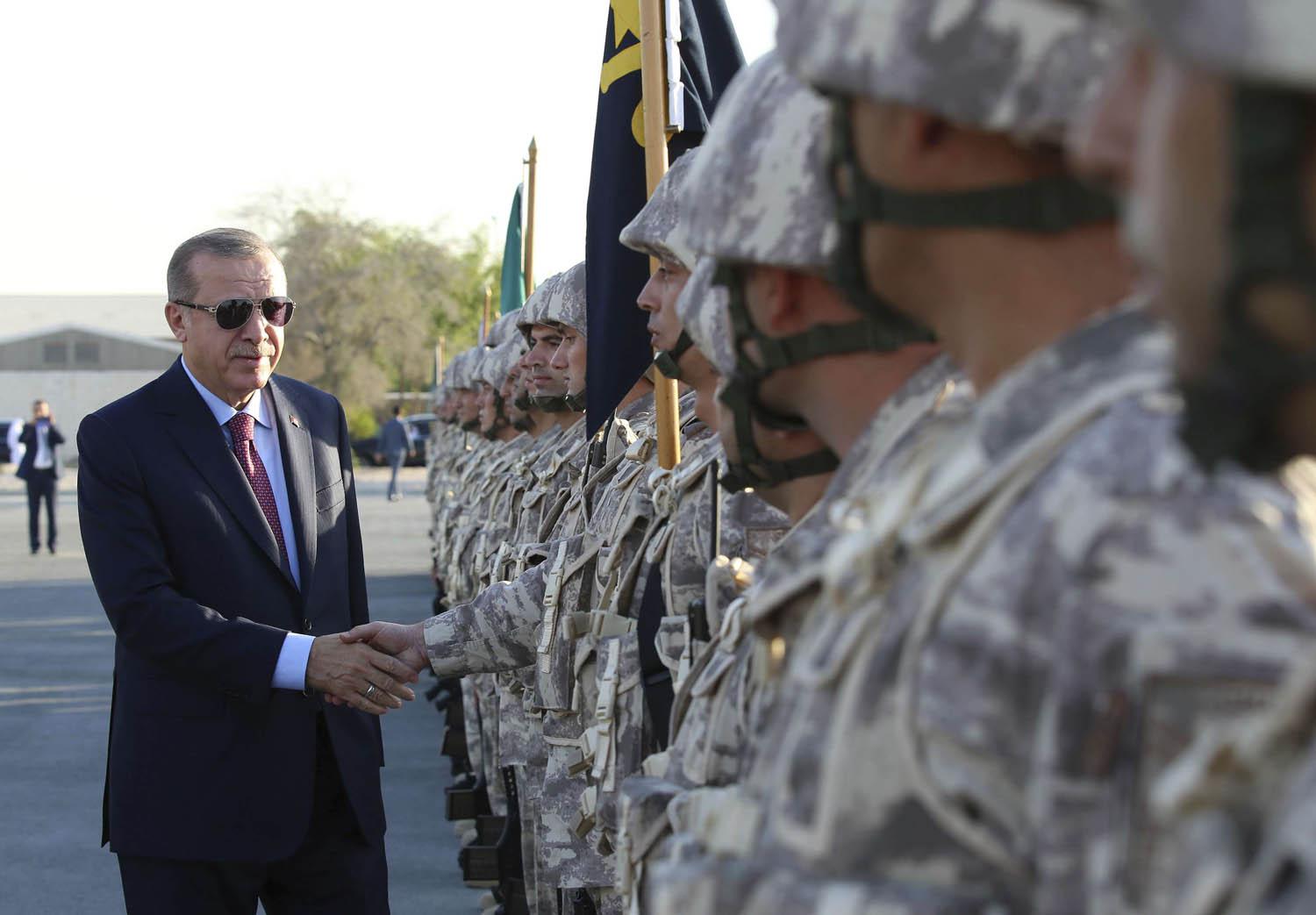 الرئيس التركي رجب طيب أردوغان يصافح جنودا أتراك في قاعدة في الدوحة