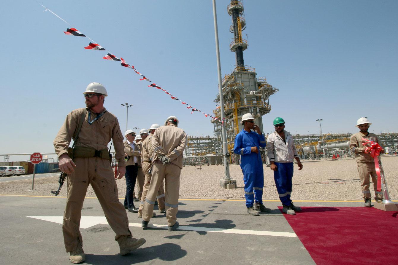 A member of security foreign personnel stays guard next to Exxon's foreign staff and Iraqi staff of the West Qurna-1 oilfield