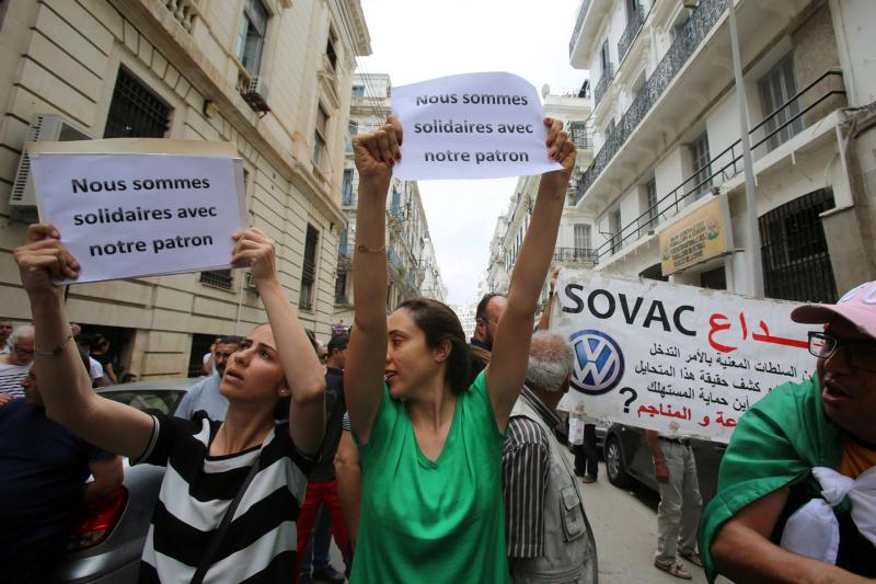 Workers carry signs in solidarity with Mourad Eulmi, the head of the Algerian family-owned firm SOVAC, a partner of Volkswagen AG, questioned in court about corruption accusations in Algiers