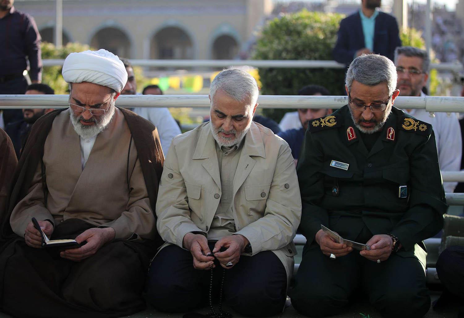 قائد فيلق القدس الإيراني قاسم سليماني يتوسط رجل دين وقائد في الحرس الثوري