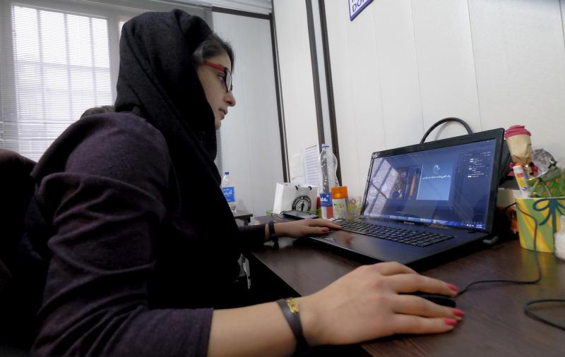 An Iranian woman works on her laptop in Tehran
