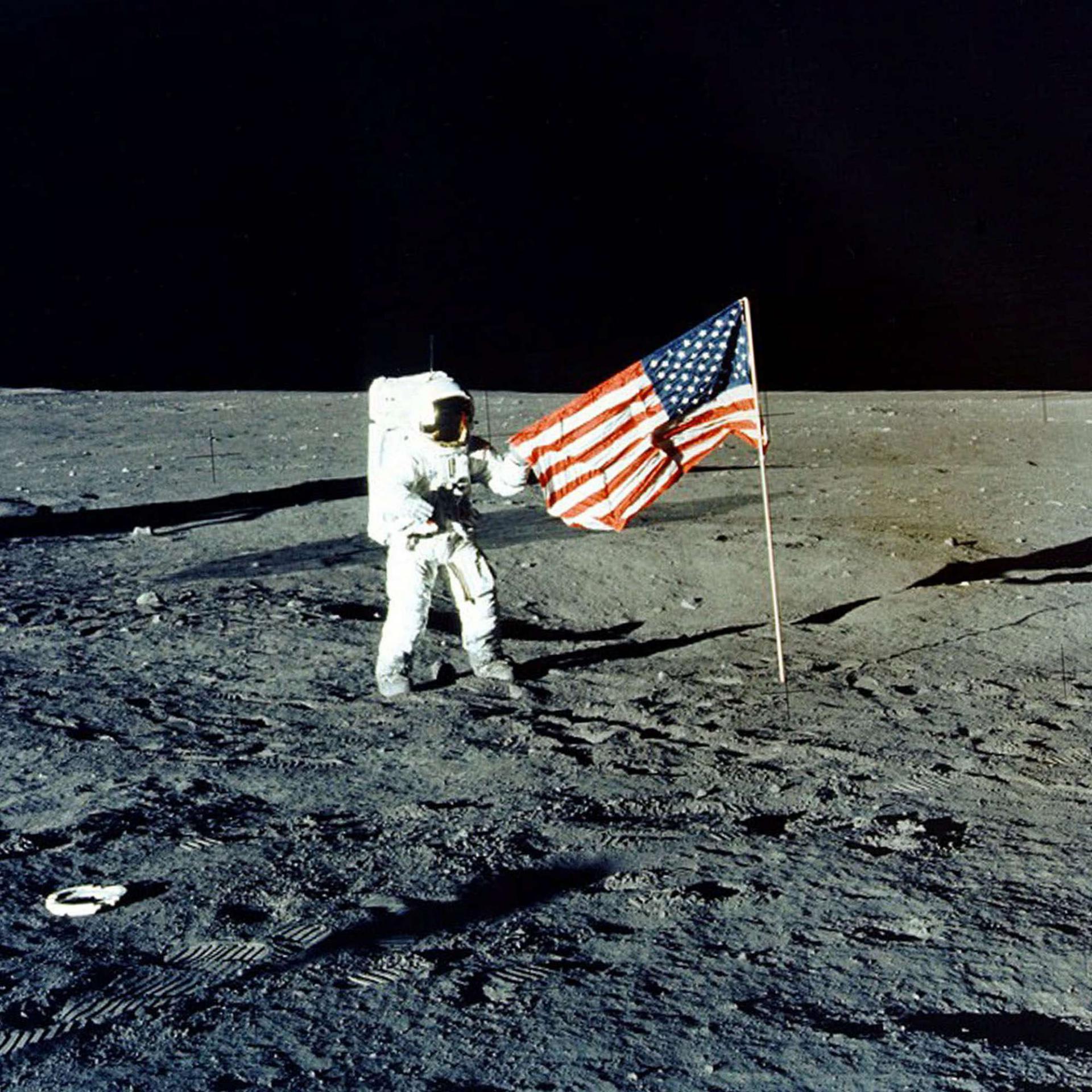 رائد فضاء أميركي في مهمة أبولو 12 يرفع العلم الأميركي على سطح القمر