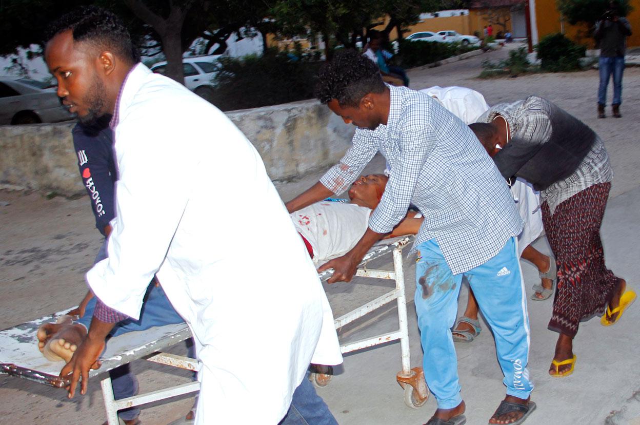 Medical workers help civilian on stretcher who was wounded in the suicide bombing