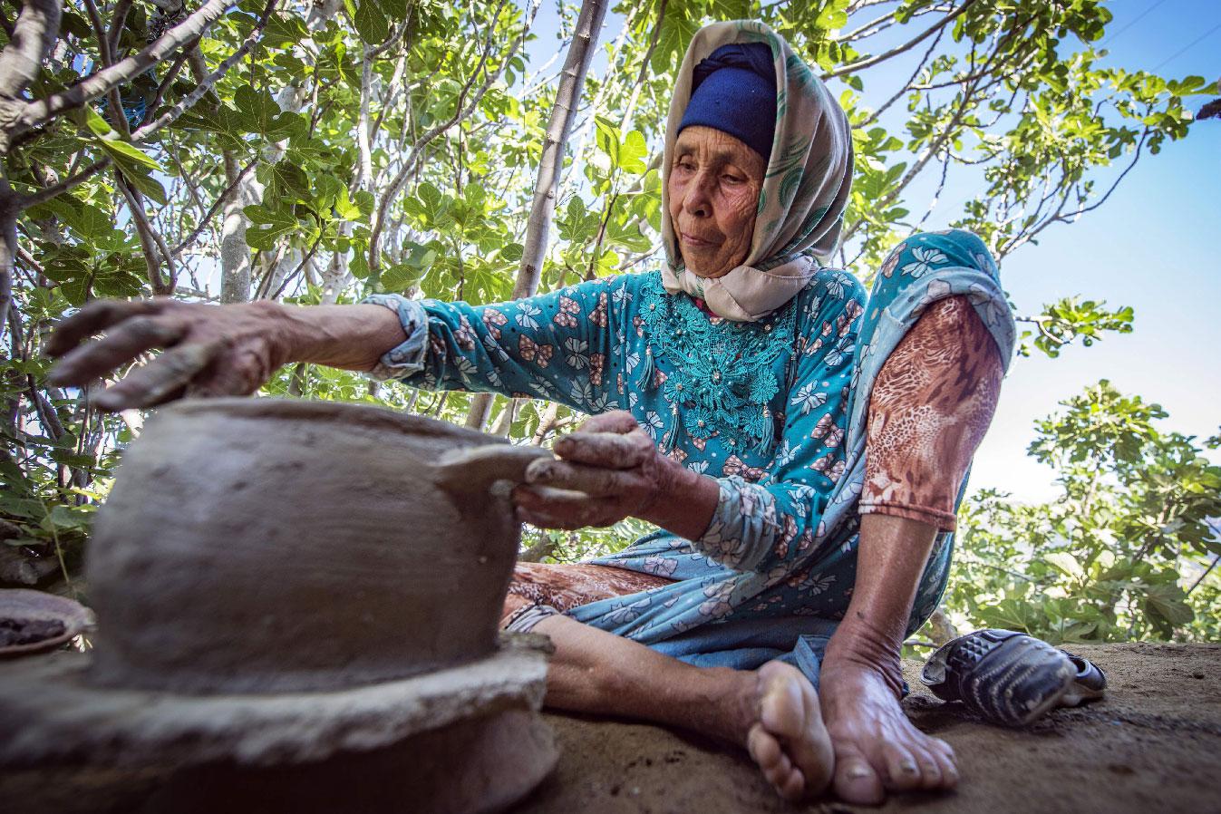 Moroccan potter Fatima Harama from the M'tioua tribe works on pottery near the village of Ourtzagh