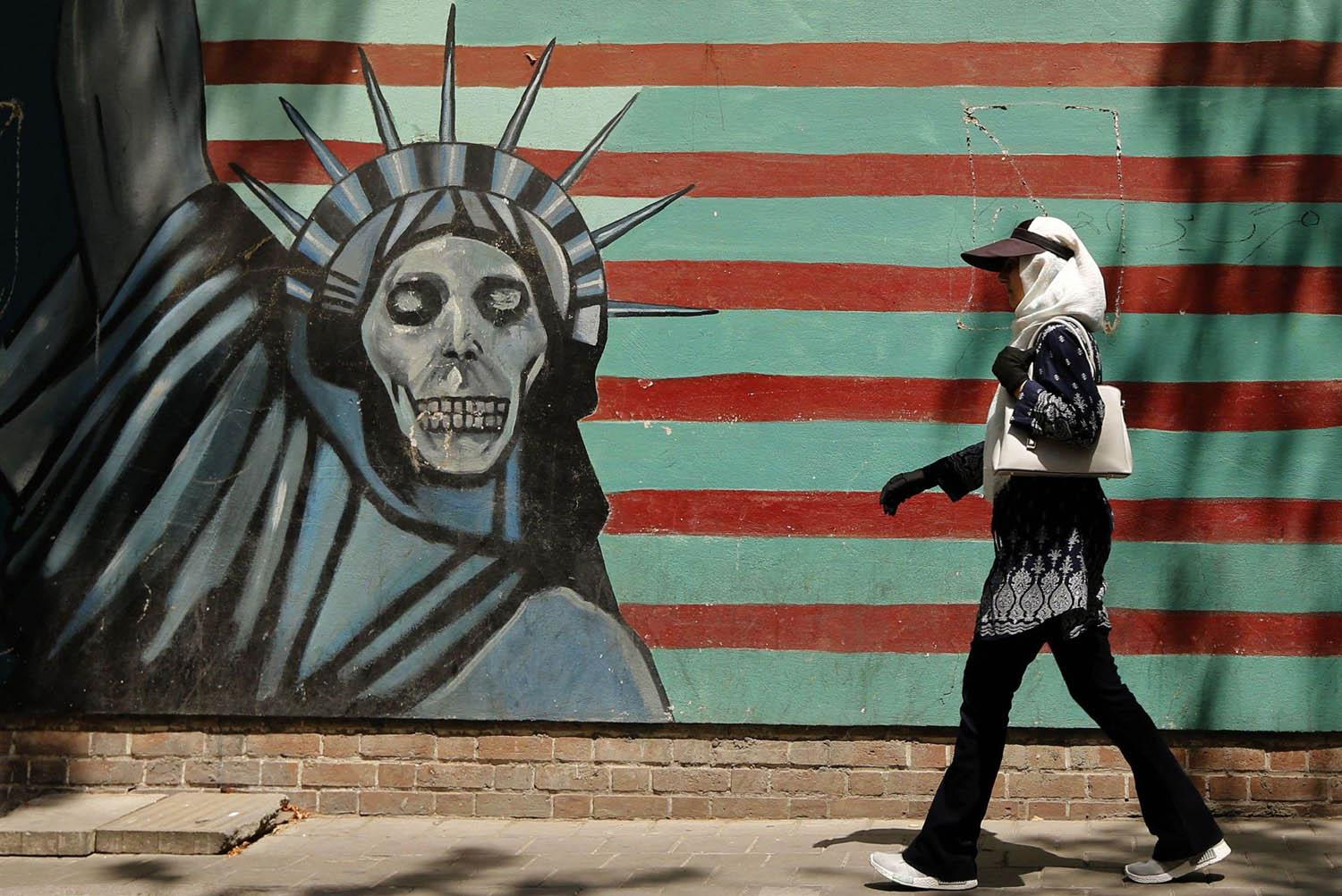 إيرانية تمر بجانب جدارية معادية لأميركا في طهران
