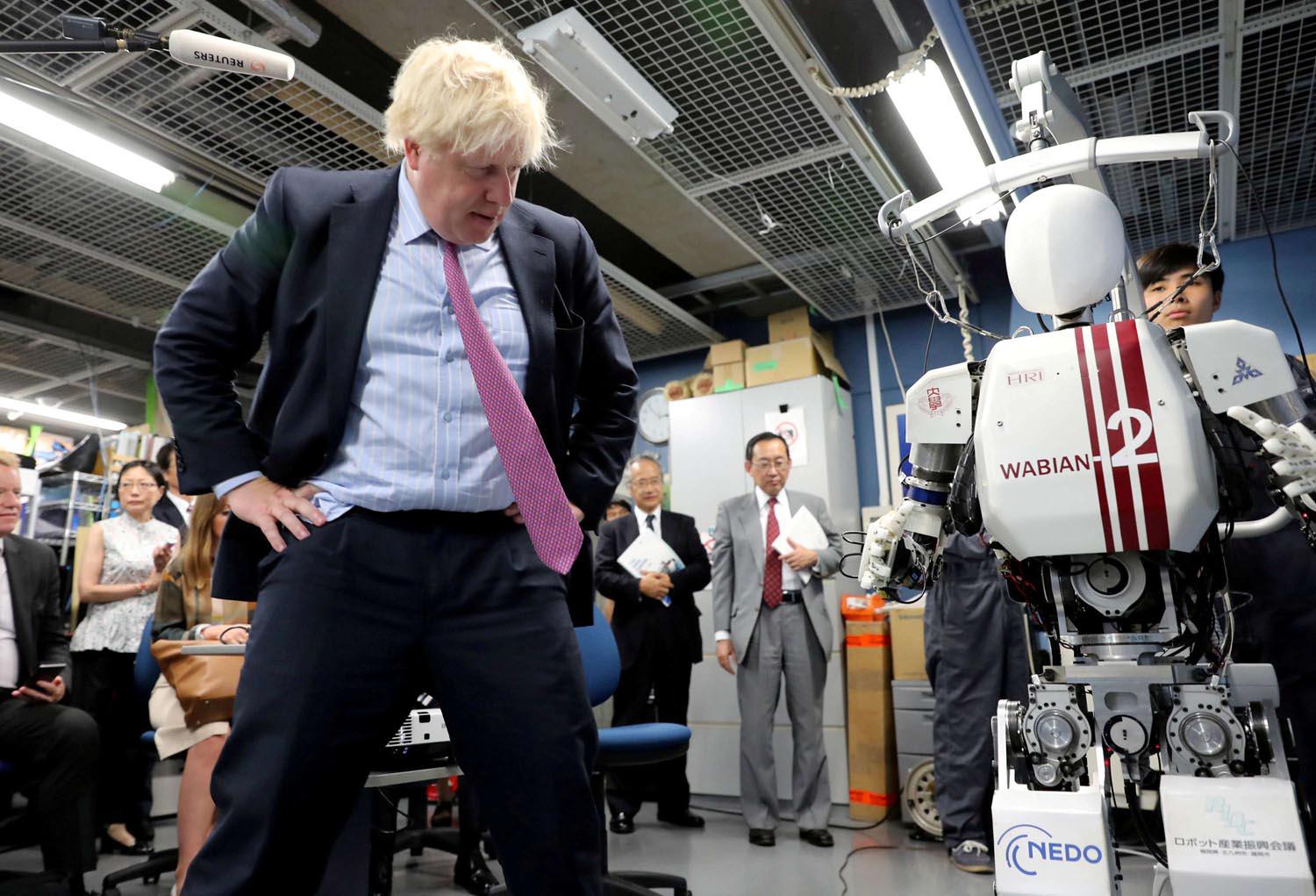 رئيس الوزراء البريطاني بوريس جونسون يستكشف روبوت في زيارة لليابان