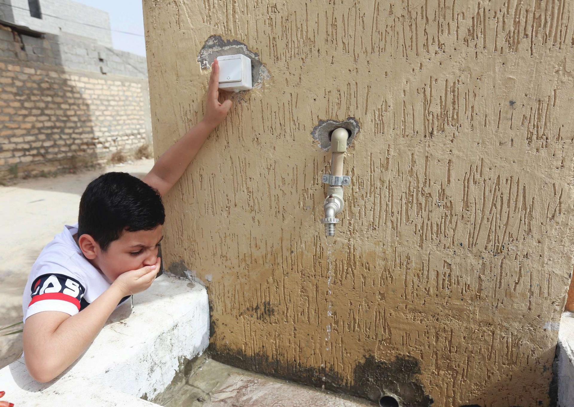 A boy drinks water during a water shortage in Tripoli, Libya